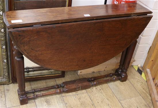 An oak oval topped folding table, W.91cm